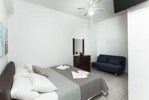sypialnia z łóżkiem i niebieskim krzesłem w obiekcie En Plo Beachfront Rooms w mieście Falasarna