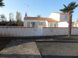 a white house with a fence and a palm tree at Maison Individuelle Agréable, Animaux Admis, Proche Plage - FR-1-476-81 in La Faute-sur-Mer +4 photos