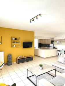 a living room with a yellow wall at Anastasias house near Athens airport in Spata