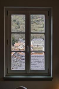 a window with a view of a town seen through it at Palmbräu Altstadt Appartments in Heidelberg