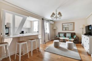 een keuken en een woonkamer met een bank en een tafel bij Amazing duplex 4P- Louvre Museum in Parijs