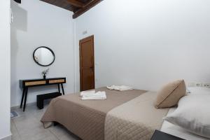 una camera da letto con un letto con specchio e un tavolo di En Plo Beachfront Rooms a Falasarna