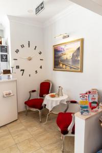 een kamer met een tafel en stoelen en een klok aan de muur bij Galley Hotel in Istanbul