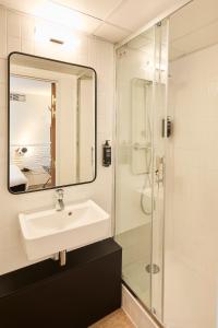ポワシーにあるibis Styles Paris Poissyの洗面台とシャワー付きのバスルーム +43枚の写真