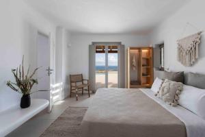 ein weißes Schlafzimmer mit Bett und Meerblick in der Unterkunft Villa Stephanie with heated pool, by Red Windmill Villas in Mykonos Stadt + 32 Fotos