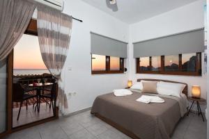 a bedroom with a bed with a view of the ocean at En Plo Beachfront Rooms in Falasarna