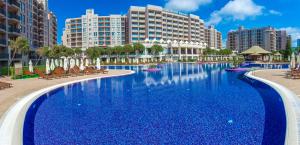 uma grande piscina com cadeiras e edifícios em Barceló Royal Beach - All Inclusive em Sunny Beach