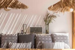 ein Wohnzimmer mit einem Sofa und Kissen in der Unterkunft Villa Stephanie with heated pool, by Red Windmill Villas in Mykonos Stadt