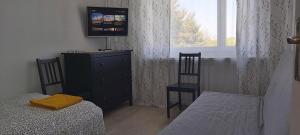 a bedroom with a bed and a dresser and a window at Apartament Trzy Pokoje in Zamość