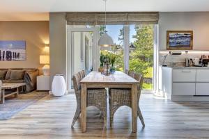 cocina y sala de estar con mesa y sillas en Ferienhaus Lodino Lodge mit Sauna und Kamin, en Loddin