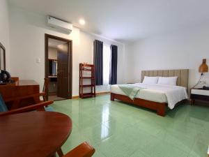 Tràm ChimにあるWildbird Hotelのベッドとテーブルと椅子のある寝室