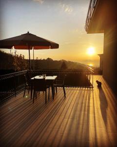 ヴィーコ・エクエンセにあるVilla Cinqueの夕日を望むデッキにテーブルと傘