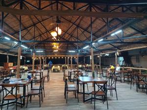a dining area with tables and chairs in a building at Wildbird Hotel in Tràm Chim