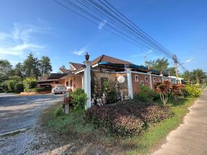 una casa a un lado de la carretera en พิณทอง รีสอร์ท, en Khlong Thom