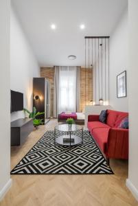 sala de estar con sofá rojo y alfombra blanca y negra en K33- Boutique Apartments, Best Location, by BQA en Budapest