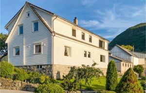 a large white house with a hill in the background at Lovely Apartment In Sandnes With House Sea View in Forsand