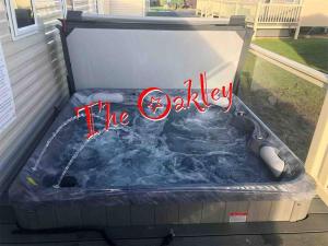 a jacuzzi tub with a sign that reads theology at Tattershall Lakes The Oakley Caravan 8 berth, Hot tub & WiFi in Tattershall