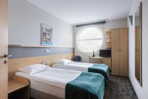una camera d'albergo con due letti e una finestra di Hotel Lechicka a Poznań