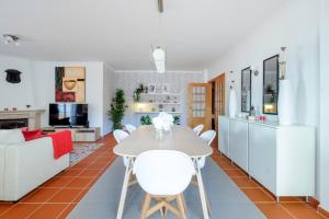 een keuken en een woonkamer met een tafel en stoelen bij Apartamento T3 Praia D'el Rey in Casal da Lagoa Seca