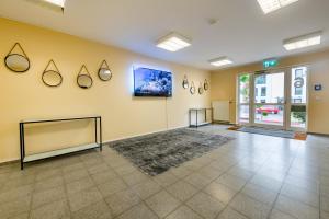 a large room with a yellow wall at Aparthotel Alma Bonn in Bonn