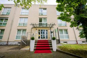 a building with a red carpet in front of it at Aparthotel Alma Bonn in Bonn