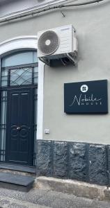 a building with a door and a sign and a fan at NobileHouse in Catania