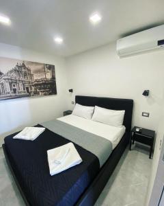 una camera da letto con un letto e due asciugamani di NobileHouse a Catania