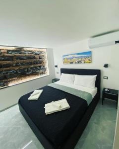 una camera da letto con un letto con due tovaglioli sopra di NobileHouse a Catania