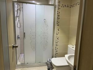 a bathroom with a shower with a toilet and a sink at Ece Han Butik Otel in Atakum