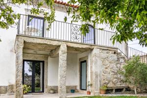 Un edificio con un balcón en la parte superior. en Casa do Mestre Studio e Suíte Extra, en Vila de Punhe