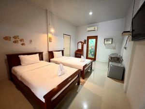 Habitación de hotel con 2 camas y TV en พิณทอง รีสอร์ท, en Khlong Thom