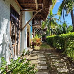 a house with a pathway next to a building at Maria Moñitos Hostel in Moñitos
