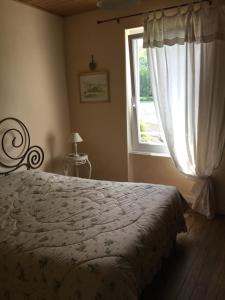 a bedroom with a bed and a window at chambre pour 2 personnes in Sablons