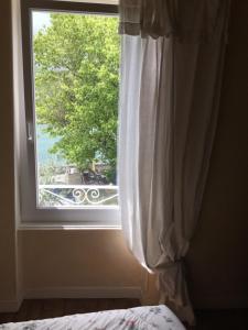 a bedroom window with a view of a tree at chambre pour 2 personnes in Sablons