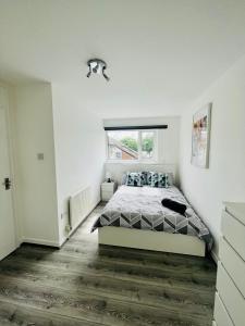 a white bedroom with a bed and a window at BEA Allenby Walk in Manchester