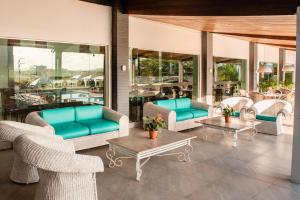 a patio with couches and tables and chairs at Hotel Village Premium Caruaru in Caruaru