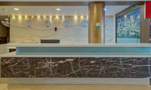 a lobby with a marble counter and a gold pole at Treebo Trend Alankar Inn in Vijayawāda