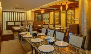 ヴィジャヤワーダにあるTreebo Trend Alankar Innのテーブルと椅子が備わるレストラン