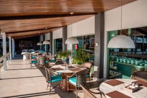a restaurant with tables and chairs on a patio at Hotel Village Premium Caruaru in Caruaru