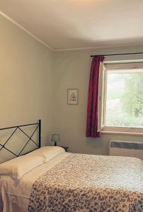 a bedroom with a bed and a window at Residenze l'Alberata in Collazzone