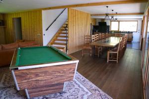 a living room with a pool table and a staircase at La grange au ruisseau in Bellecombe-en-Beauges