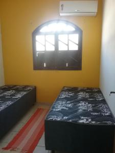 Duas camas num quarto com uma janela em Xicabacana Hospedaria em Mata de São João