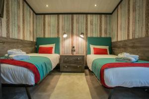 twee bedden in een kamer met gestreepte muren bij Mersea Island by Away Resorts in Colchester