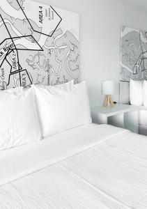 1 dormitorio con 1 cama con sábanas blancas y lámpara en Oneway Brunswick, en Brunswick