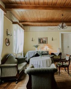 Dwór Mościbrody في سيدلس: غرفة معيشة مع سرير وطاولة وكراسي
