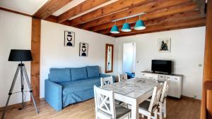 スーストンにあるS-Pinède 01-Soustons Villa duplex 2 chambres dans résidence familiale avec piscineの青いソファとテーブルのあるリビングルーム