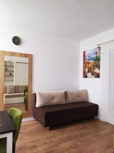 ein Wohnzimmer mit einem Sofa und einem Spiegel in der Unterkunft Studio Petlja - Igalo in Herceg-Novi