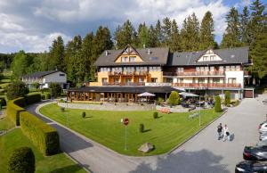 un grand bâtiment avec des personnes qui marchent devant lui dans l'établissement Hotel SLUNEČNÁ LOUKA, à Lipno nad Vltavou