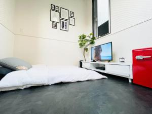 a bedroom with a bed and a flat screen tv at Alo BnB 4 - Near SHINJUKU, SHINOKUBO - Self check-in in Tokyo