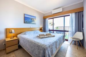 a hotel room with a bed and a balcony at Clube Praia Mar Flat T1 in Portimão